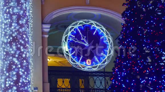 城市的蓝色圣诞树闪烁的灯光花环和时钟视频的预览图