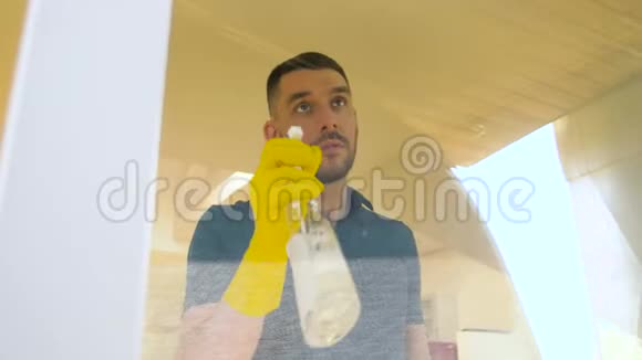 戴橡胶手套的人用抹布擦窗户视频的预览图