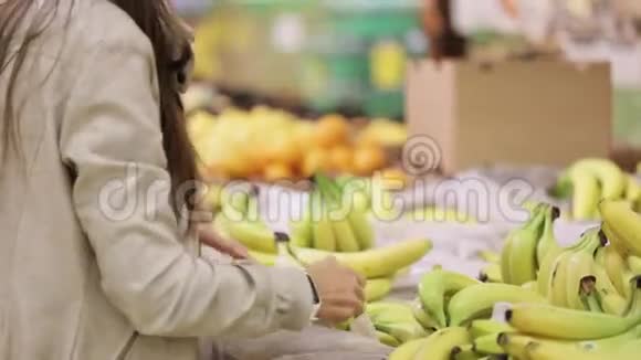 在杂货店买新鲜香蕉的年轻女性视频的预览图