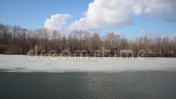 春天冰融化在河上白云在河上视频的预览图