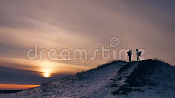 人冬天剪影做自拍拍照欢乐雪阳光一群游客走在夕阳的剪影之上视频的预览图