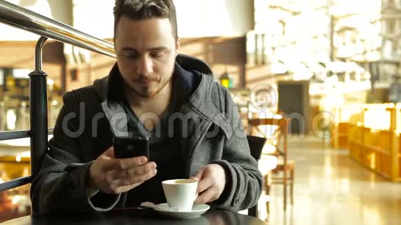 成年人在一个大型购物中心的咖啡馆里使用电话和喝咖啡视频的预览图