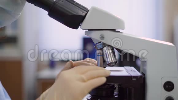 利用实验室显微镜进行医学样品的放大和研究一只手的形象视频的预览图