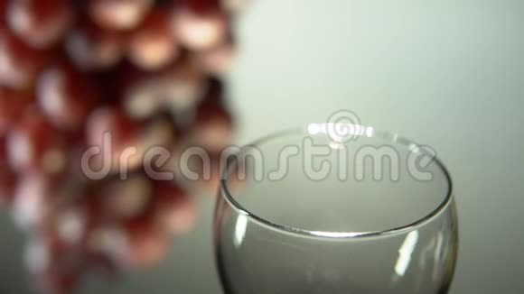 红酒倒在一个淡背景上的杯子里视频的预览图