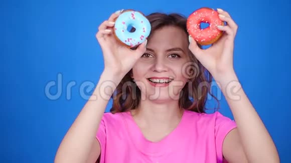 美女带着五颜六色的甜甜圈有趣的快乐女孩糖果视频的预览图