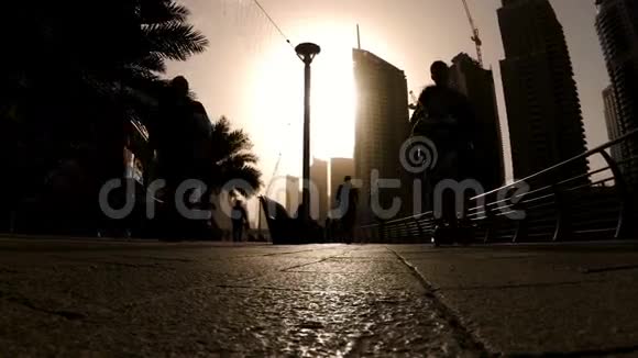日落时分在迪拜码头散步和慢跑的人剪影视频的预览图