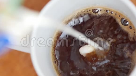 将牛奶倒入一杯咖啡中的慢动作视频视频的预览图