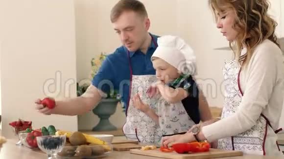 一个美丽的家庭正在家里的厨房准备一份美味的水果沙拉视频的预览图