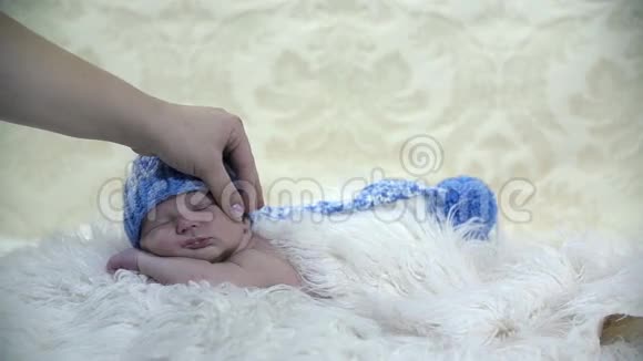 妈妈抱着婴儿的头睡在毛茸茸的毯子上视频的预览图