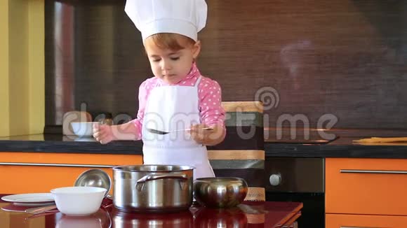 穿着厨师服的小可爱的孩子在厨房的盘子里安排意大利面视频的预览图