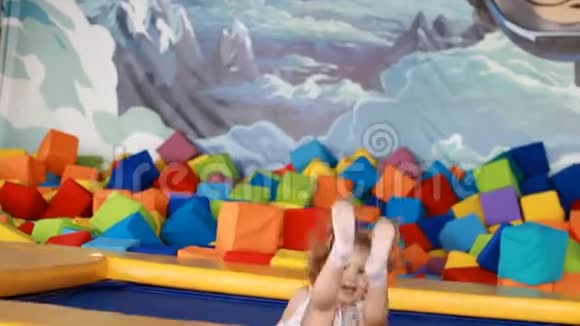 小女孩在操场上蹦床上为孩子们跳孩子们的游戏视频的预览图