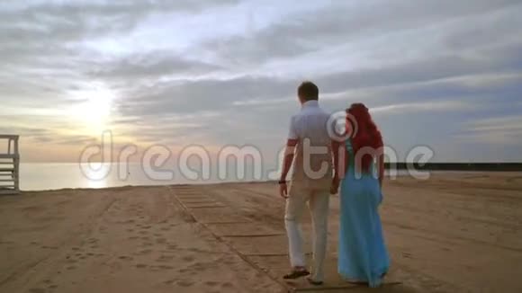 情侣在日出时在海边散步双人沙滩视频的预览图