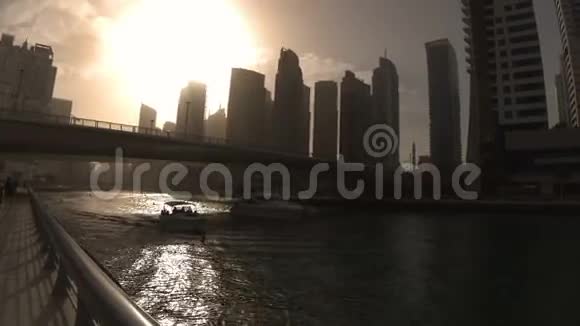 日落时分两艘船从迪拜码头的桥下经过视频的预览图