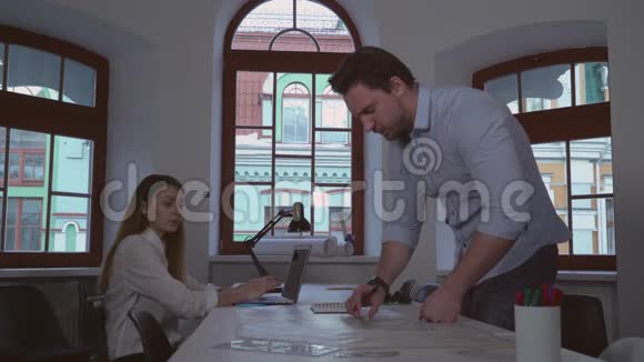 成人设计师和助理坐在办公桌前视频的预览图