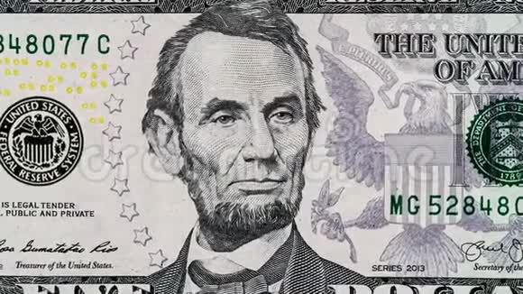 创意4k视频五个美元钞票细节与亚伯拉罕林肯的特写肖像他的发光眼睛的效果视频的预览图