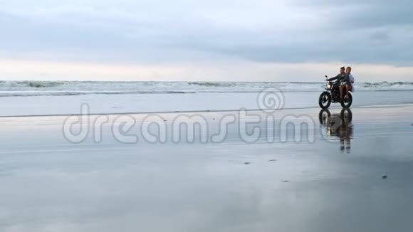年轻漂亮的夫妇潮人骑复古摩托车在海滩上户外肖像骑男女旅行视频的预览图