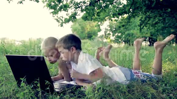 两个穿白衣服的男孩躺在草地上视频的预览图