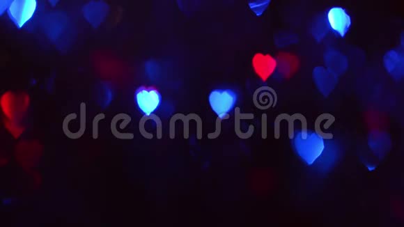 浪漫的波克蓝色红色绿色的灯光在黑暗中五颜六色的灯光在一颗心的形状上闪闪发光视频的预览图
