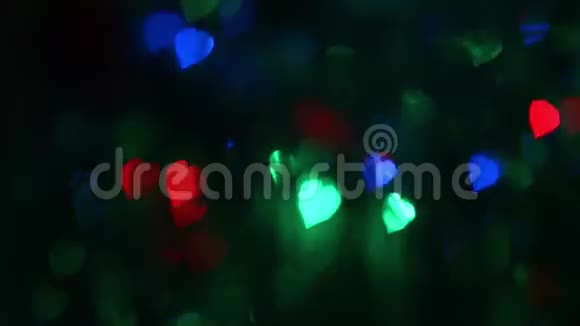 深色背景上的多彩圆形闪烁灯离焦的彩灯闪耀着蓝色红色绿色的光芒视频的预览图