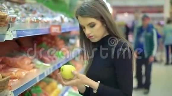 美丽的年轻女子在杂货店买水果产品视频的预览图