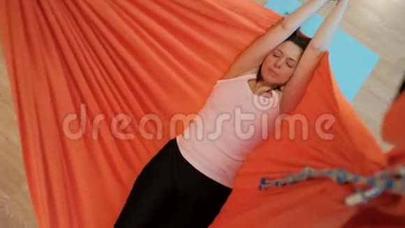年轻女子躺在室内吊床上冥想视频的预览图