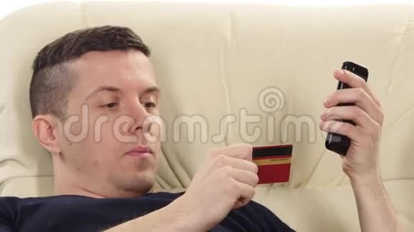 男人用金卡和手机购物白色的关门视频的预览图