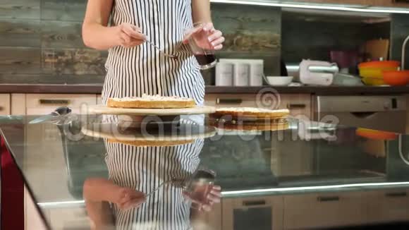 女人浸渍海绵蛋糕家庭烘焙海绵蛋糕躺在餐桌上视频的预览图