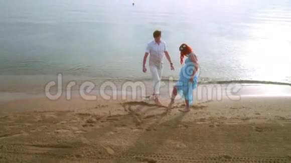 在沙子上画心脏符号浪漫情侣在海滩上画心形视频的预览图