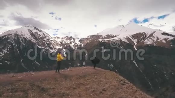 一个男人在山的边缘给一个女人拍照视频的预览图