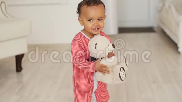 可爱微笑的非洲宝宝带着玩具熊玩具视频的预览图