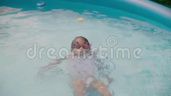 快乐的小女孩在游泳池里学习游泳爸爸和女儿一起笑慢动作视频的预览图