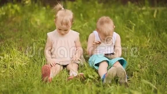 孩子们坐在草地上孩子不给女孩电话视频的预览图