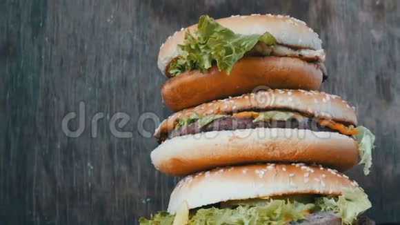 大山从三个美味多汁的汉堡与生菜和奶酪近景汉堡包一只躺在视频的预览图