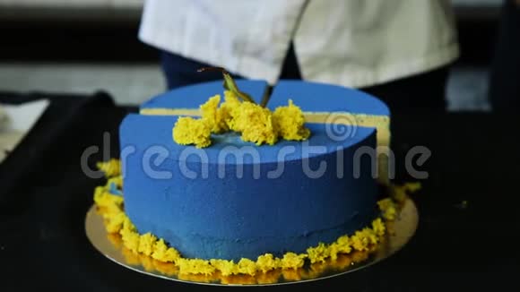 糖果手把蓝色装饰的蛋糕切成块视频的预览图