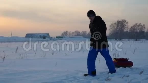 那个家伙用雪管上升到雪山慢动作冬天的雪景日落时间视频的预览图