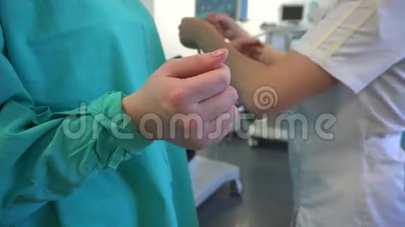 护士帮助外科医生穿着医用长袍视频的预览图