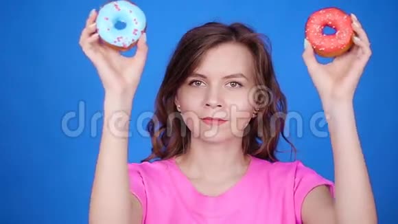 美女带着五颜六色的甜甜圈有趣的快乐女孩糖果视频的预览图
