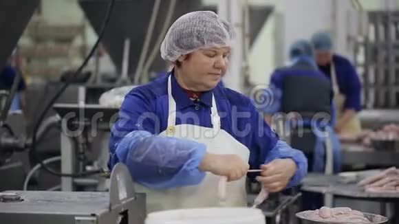 食品厂工人在自动化食品生产设备上生产香肠视频的预览图
