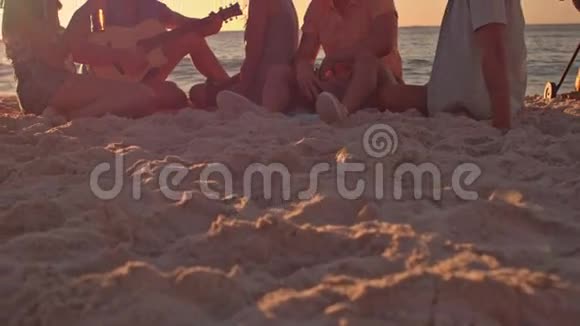朋友们坐在沙滩上弹吉他视频的预览图