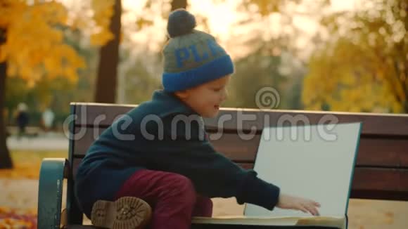 小男孩正在秋天公园看大家庭相册然后把它留下视频的预览图