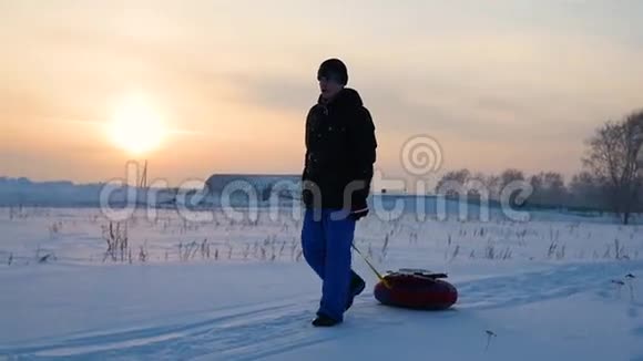 那个家伙用雪管上升到雪山慢动作冬天的雪景日落时间视频的预览图