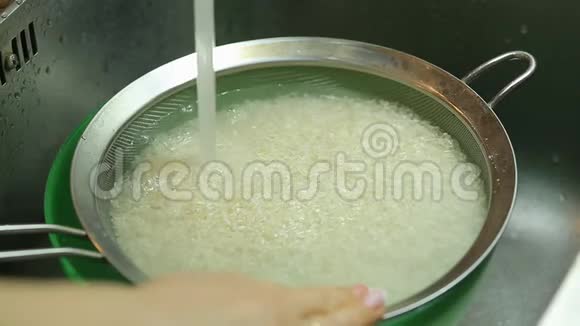 家庭主妇在厨房里洗米饭在家煮饭视频的预览图