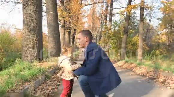 爸爸把婴儿扔到户外秋天的森林幸福家庭价值观视频的预览图