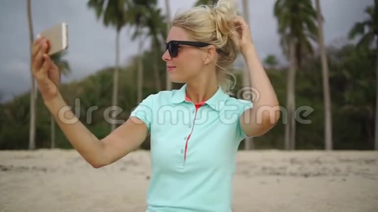 快乐的女人在海滩上拍自拍照片视频的预览图