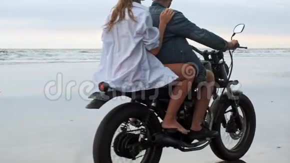 年轻漂亮的夫妇潮人骑复古摩托车在海滩上户外肖像骑男女旅行视频的预览图