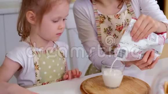 女人和女孩在厨房喝牛奶视频的预览图