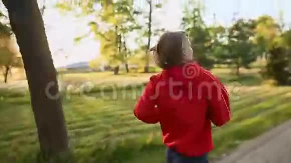 日落时分一位年轻女士在乡村的道路上奔跑视频的预览图