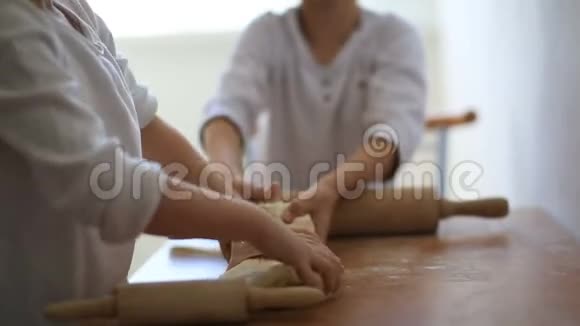 女儿和儿子都穿着白色T恤在同一张桌子上准备馅饼周末和家人在一起男孩和女孩卷视频的预览图