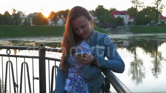 在城市公园使用智能手机的漂亮快乐女人stealam射击视频的预览图