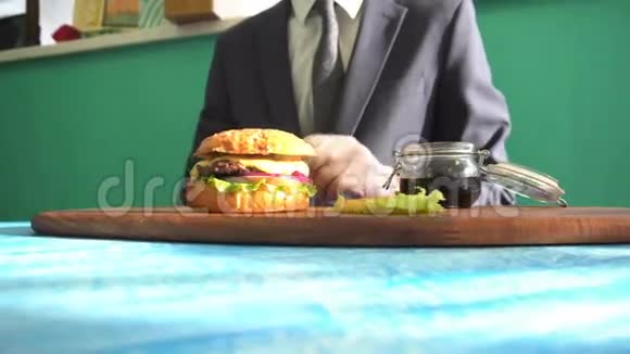 在餐馆里男人带着带手套的汉堡包视频的预览图